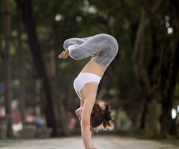 Woman demonstrating a core-strengthening yoga pose outdoors.
